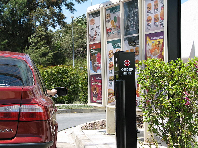 a car pulling up to a Drive thru digital signage display